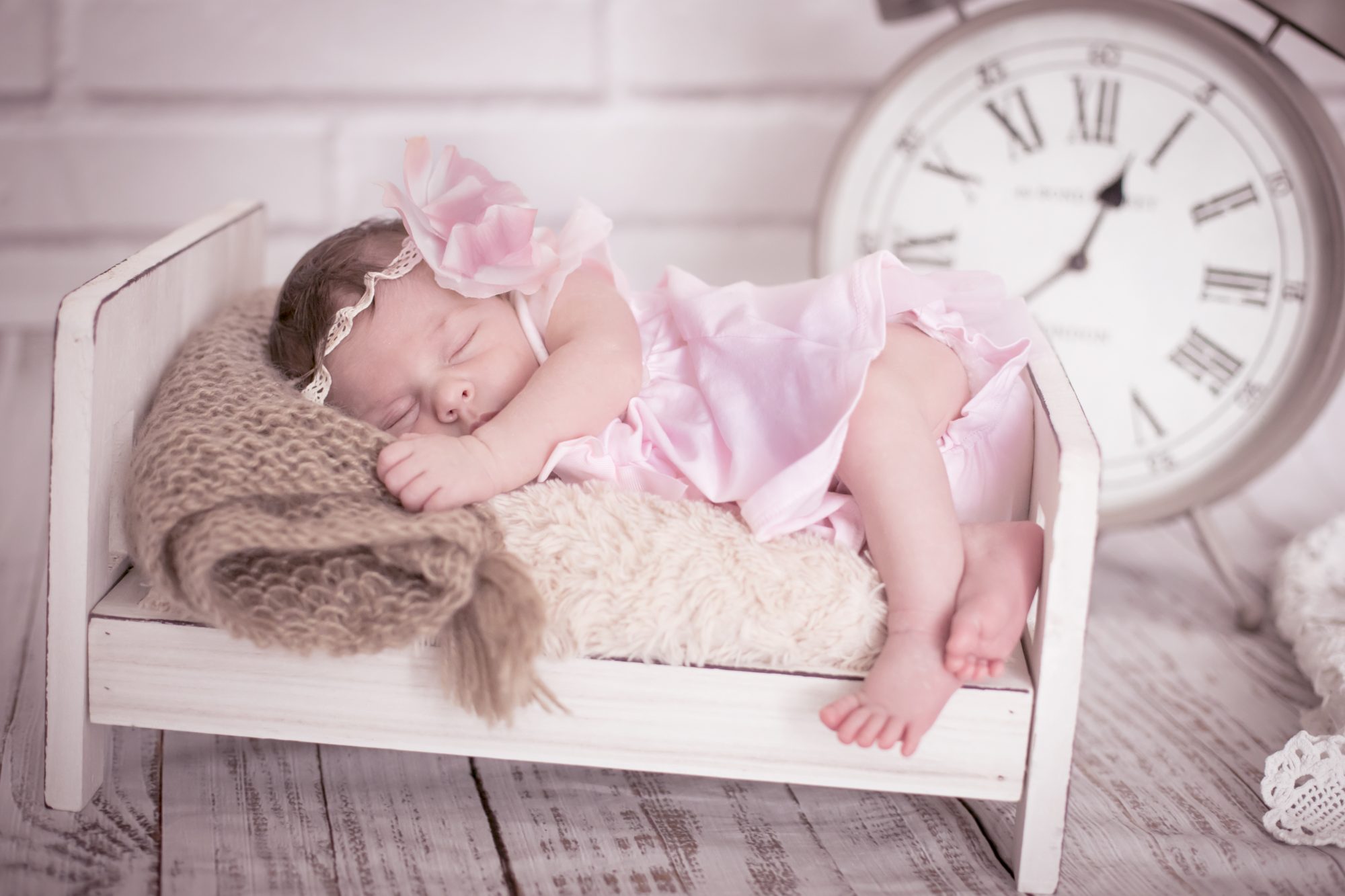 baby fotoshooting newborn fotostudio bilifotos.ch luzern baby foto in rosa zeigt wie baby in weissem bett liegt