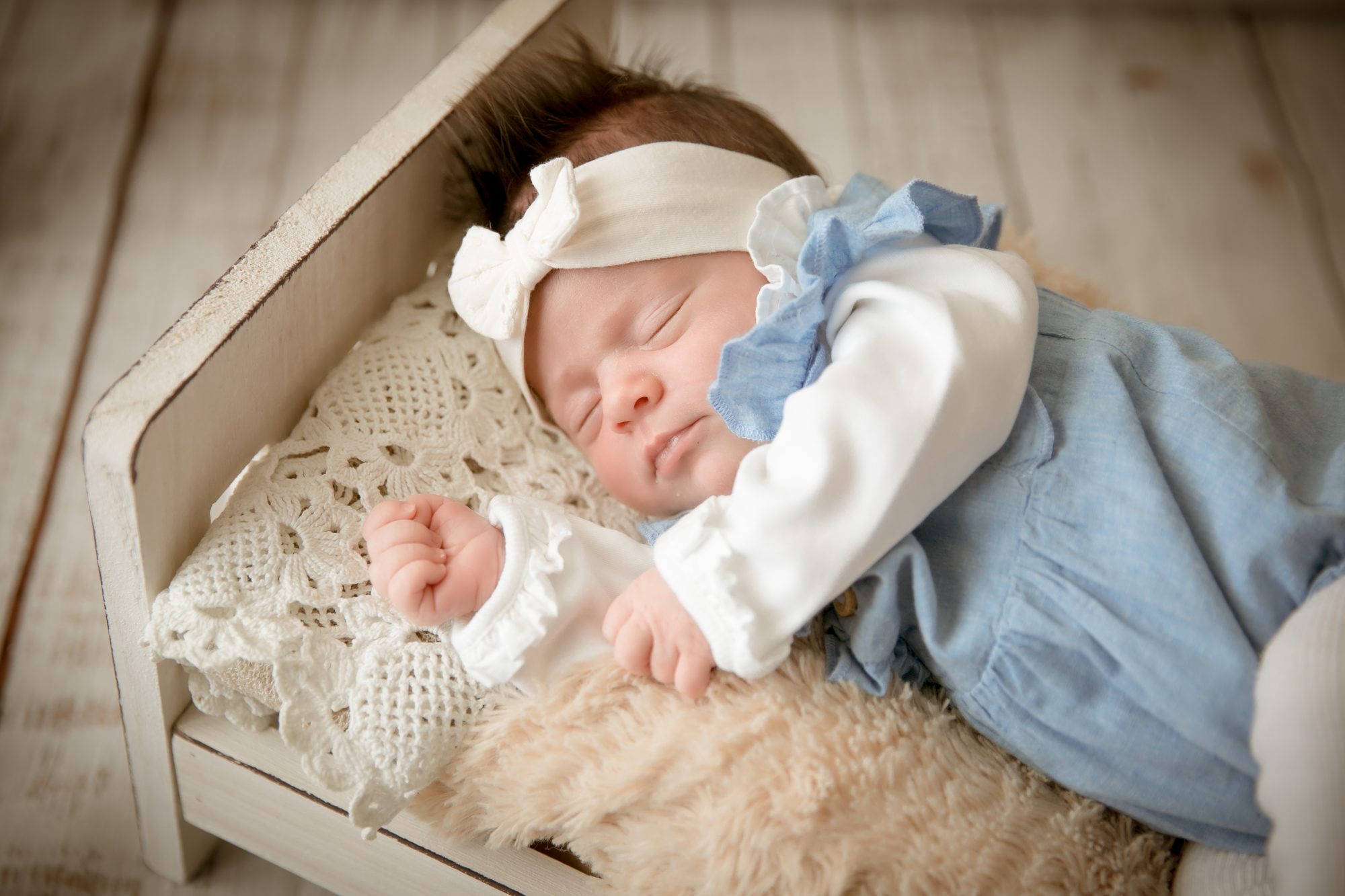 baby fotoshooting newborn fotostudio bilifotos.ch luzern baby foto zeigt wie baby im kleinen weissen bett liegt
